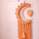 Handmade peach and off white macrame dream catcher wall hanging with tassels in boho home decor setting near window