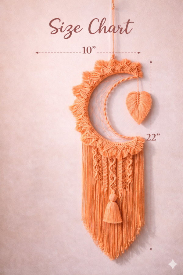 Handmade peach and off white macrame dream catcher wall hanging with tassels in boho home decor setting near window