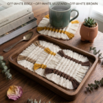 Handwoven macramé coasters in beige mustard and brown placed on wooden tray with mug
